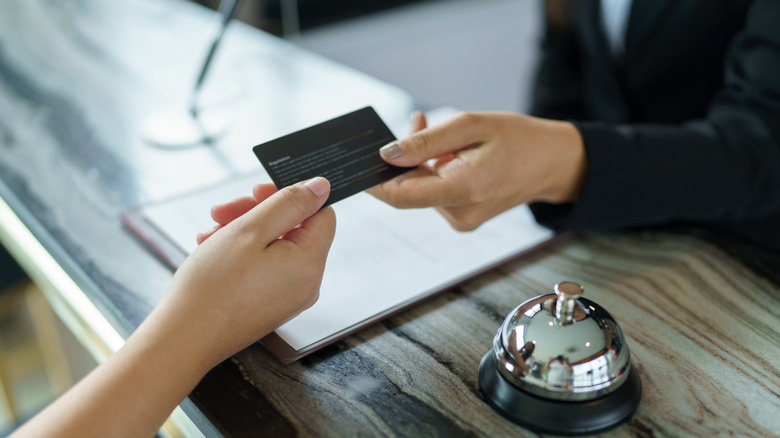 A woman paying with her travel credit card
