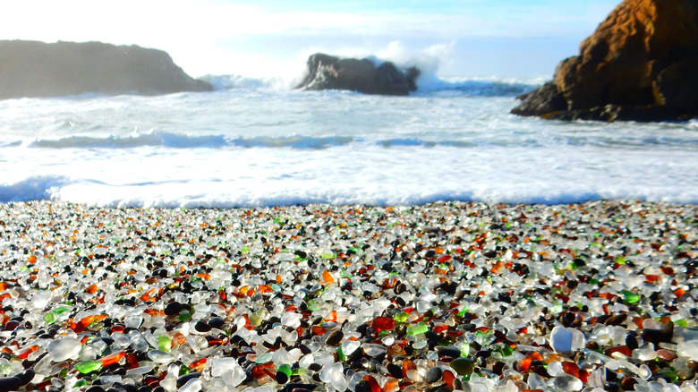 tide of a wave covering a beach full of glass pebbles