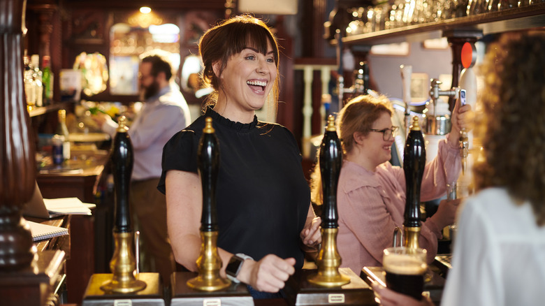 A server behind the bar at a real ale pub in the U.K.