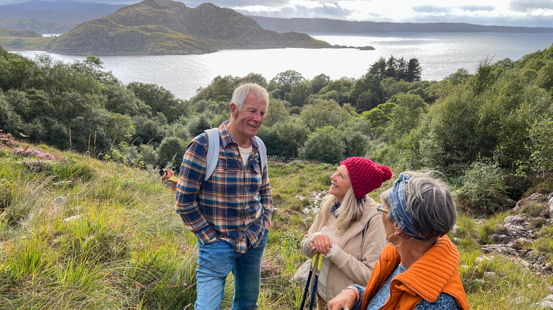 Group of senior friends talking to each other up a hill near the village of Diabaig in the west highlands of Scotland