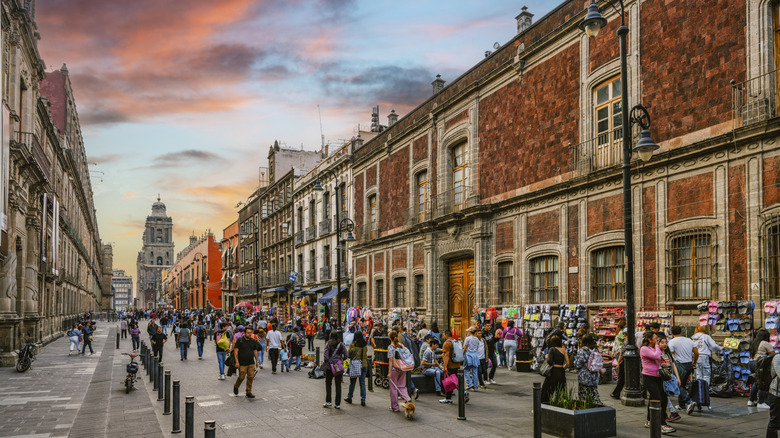 People walking in historic center of Mexico City at sunset