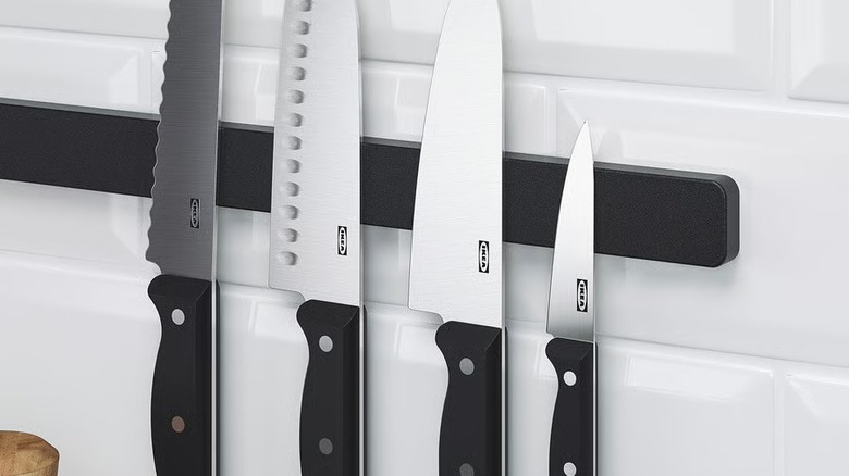 A magnetic knife holder with four IKEA brand knives