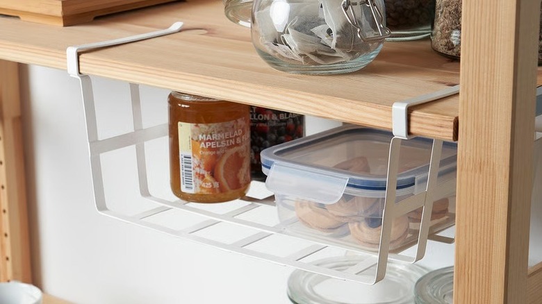 A clipped-on under-shelf basket holds food in a kitchen