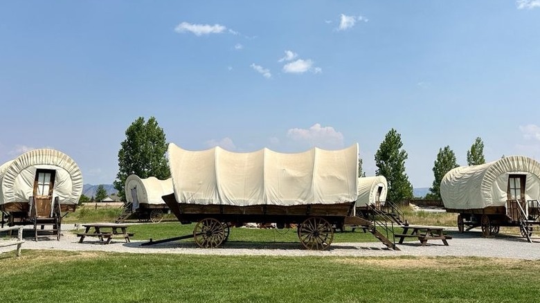 Conestoga Ranch Resort, with wagons in the foreground and mountains in the distance