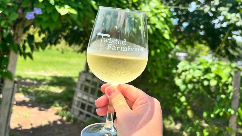 wine glass of white wine with twisted farms label on it