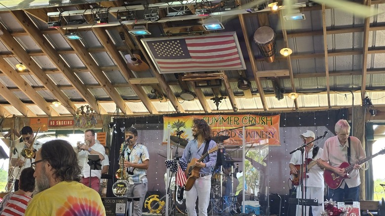 band on a stage with the american flag hanging from the ceiling