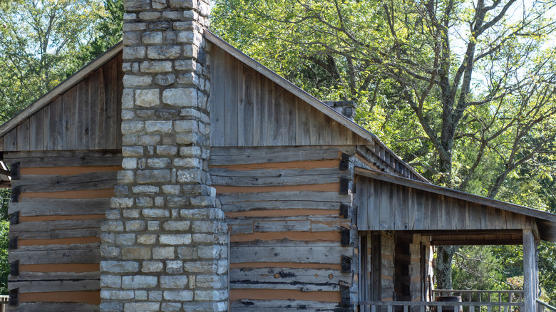 a wooden cabin with a stone chimney
