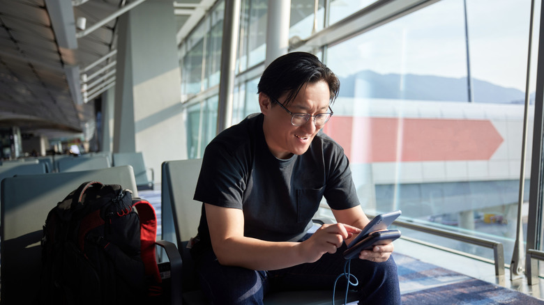 A man happily checking his phone