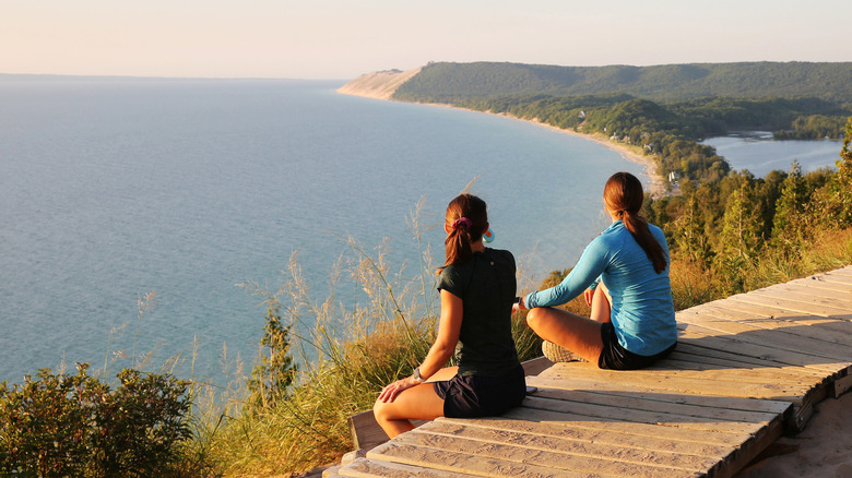 Tourists enjoying beautiful sunset scenery at the Empire Bluff Scenic Lookout, overlooking Lake Michigan from Sleeping Bear Dunes National Lakeshore