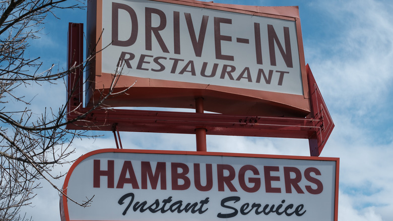 A vintage drive-in sign seen from the road