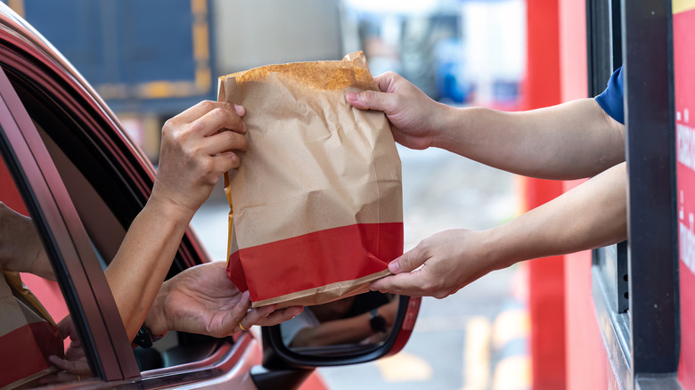 A customer receives a drive-through order at a fast food restaurant.
