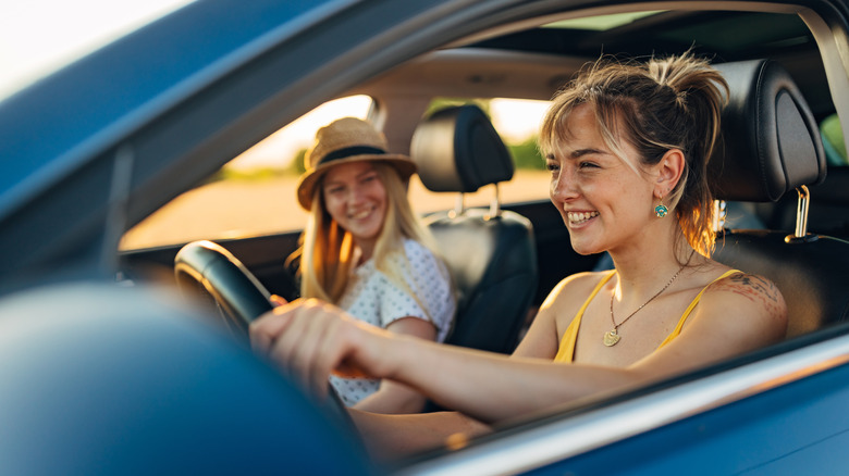 Two women sit happily in a car