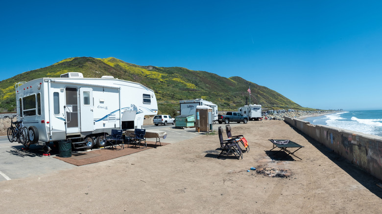 Coastline in Malibu with RV parking, folding chairs, and camping gear