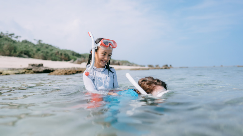 Child snorkeling with parent