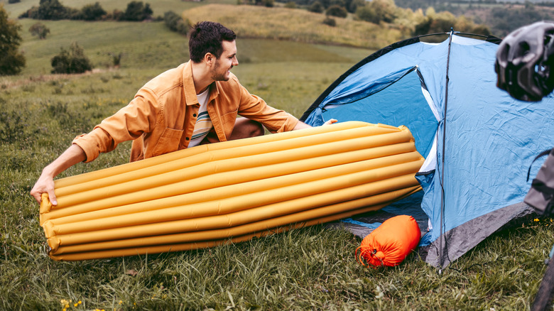 amper setting up his air bed for camping