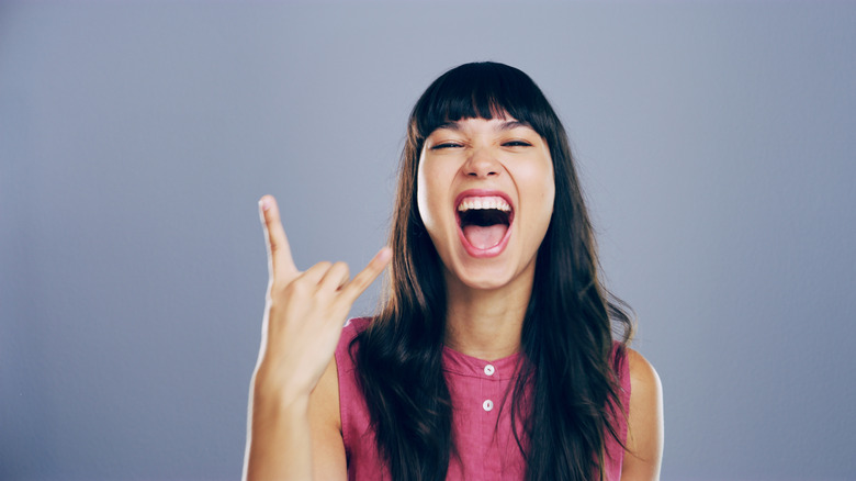 woman showing horns sign