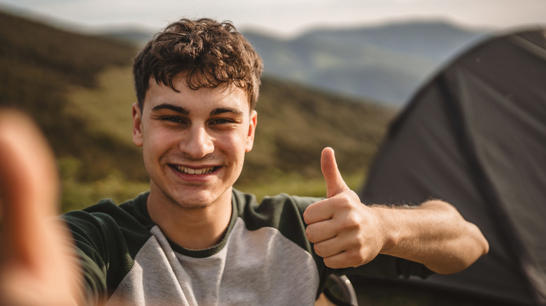 boy with thumb up camping
