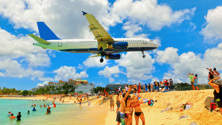 Visitors peer at a plane above Maho Beach in Sint Maarten