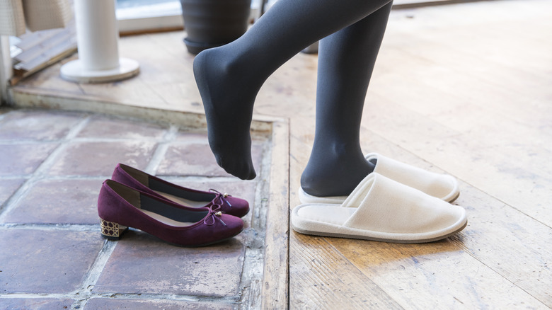 View of person taking off shoes and putting on slippers