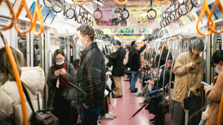 People on Tokyo Metro train, many wearing facemasks