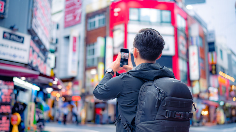 Back side of someone taking a photo of the buildings in Shinjuku, Tokyo