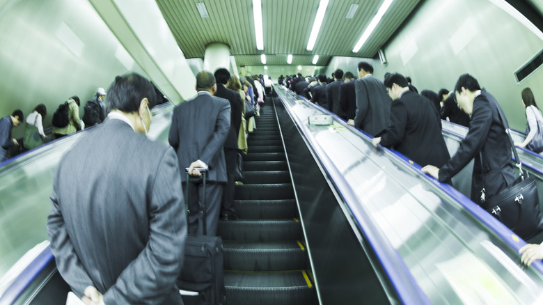 Escalator in Tokyo with people standing on one side