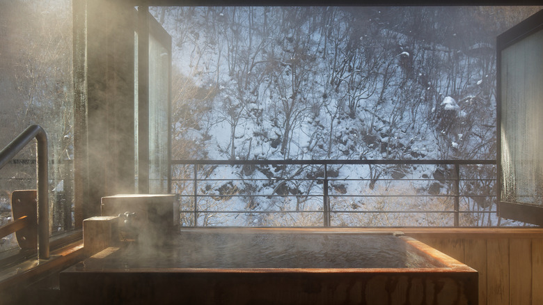 Private hot spring bath with steam and snowy landscape in Japan