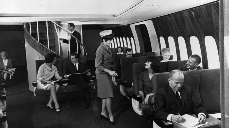 First class passengers with staircase and flight attendant