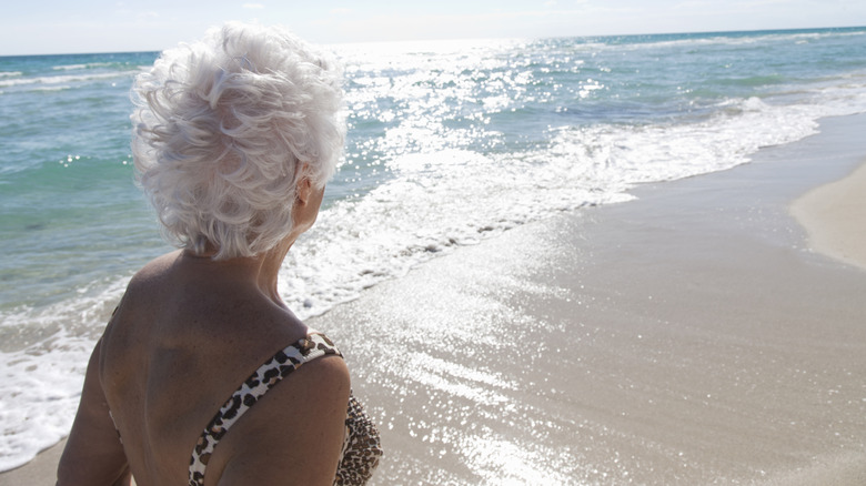 An older woman looks out at ocean