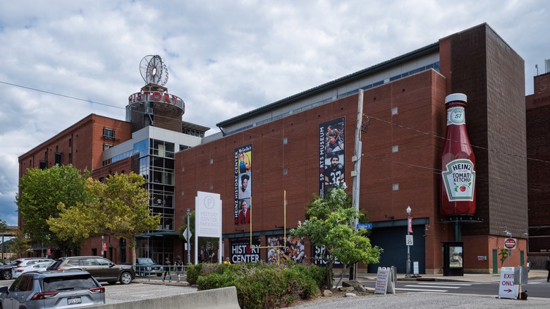 The Heinz History Center, featuring large brick walls, a famous ketchup bottle replica, and a parking lot in Pittsburgh