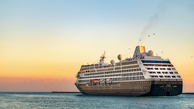 Azamara Onward cruise ship in open water with a beautiful sunset in background