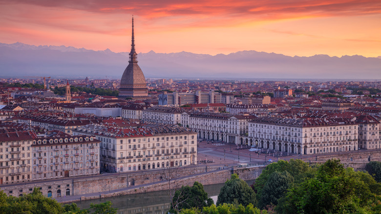 the skyline of Turin at golden hour with the Alps in the background