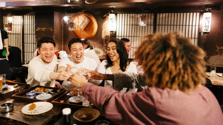 Group of people clinking glasses in a Japanese restaurant