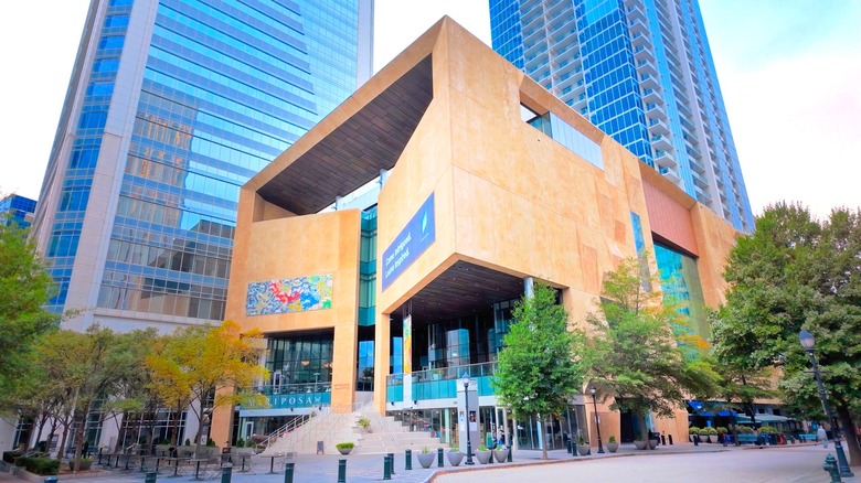 The tan stone and glass angular exterior of The Mint Uptown museum in Charlotte, North Carolina