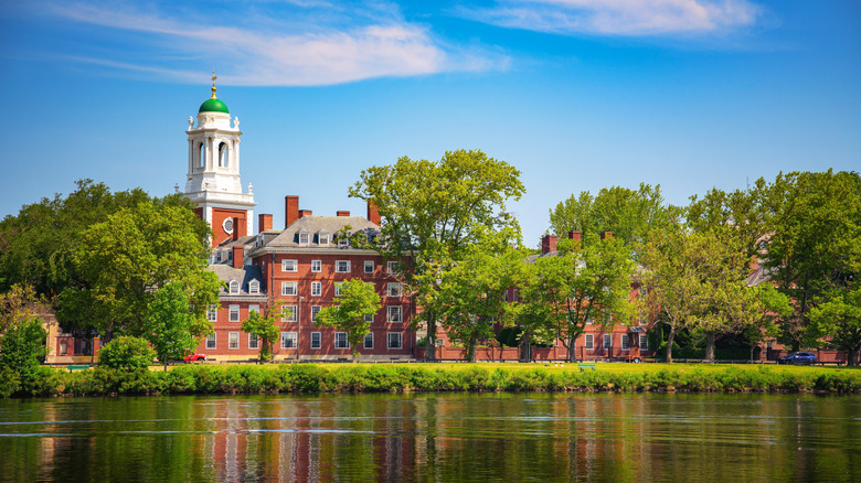 Harvard University building surrounded by trees, as seen across the Charles River in Cambridge, Massachusetts