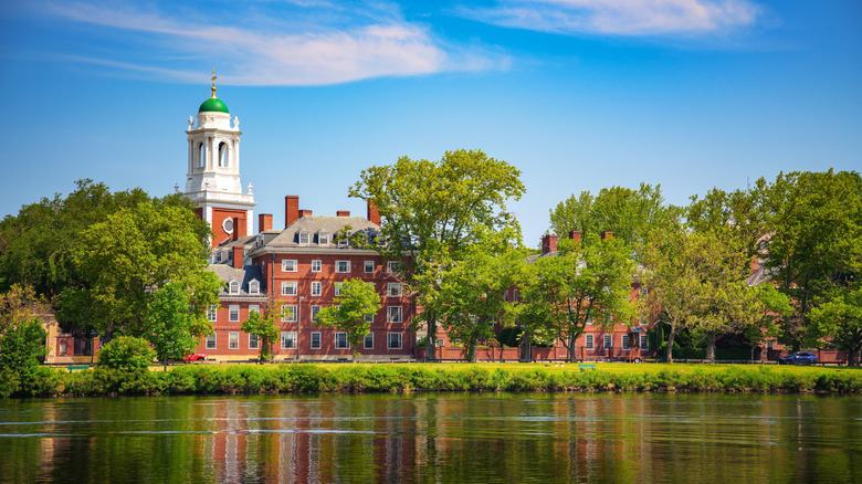 Harvard University building surrounded by trees, as seen across the Charles River in Cambridge, Massachusetts