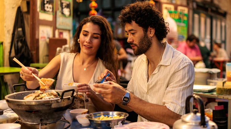 A couple eating hot pot in an outdoor food stall