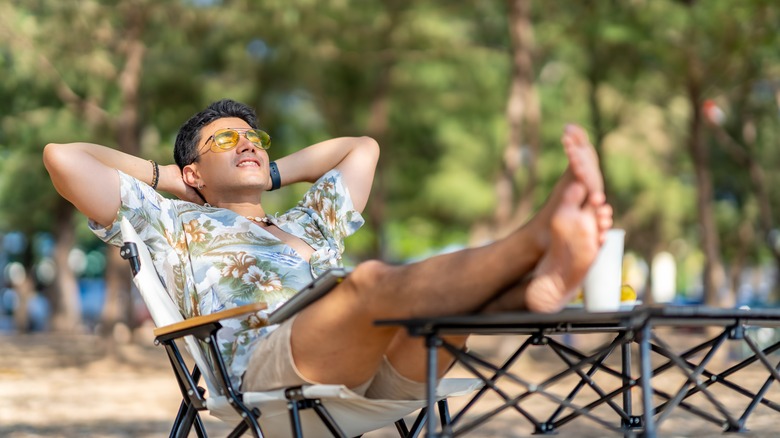 Young man relaxing on chair on tropical beach