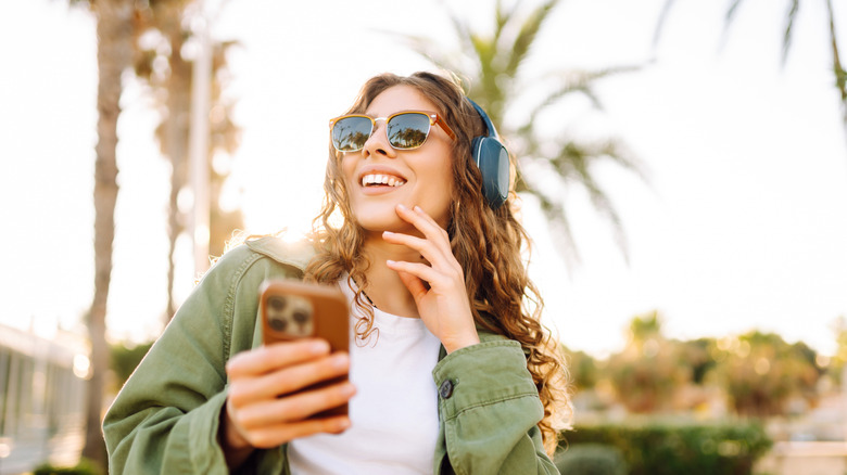 Woman smiling during a walk with palm trees in the background