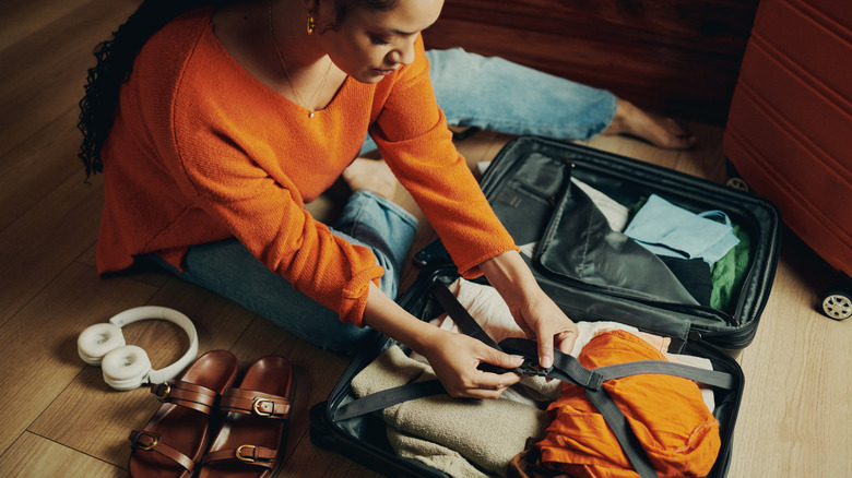 A woman packing a suitcase