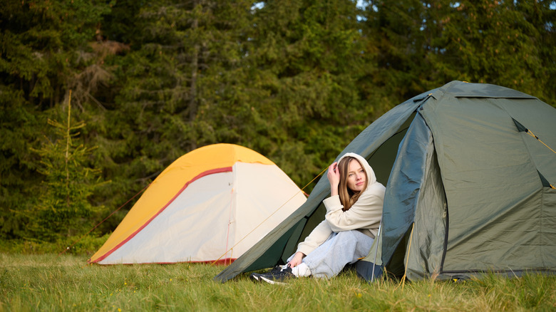 Woman sitting at a camping tent entrance