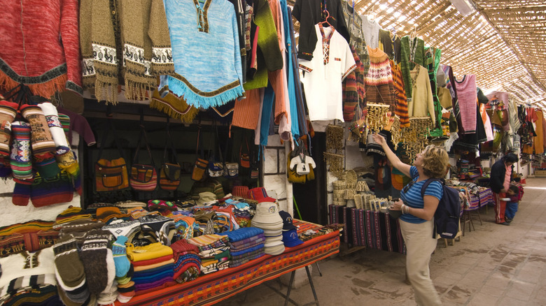 A woman browses a traditional market in Chile.