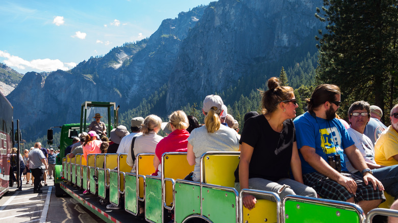 Travelers on an open-air tram tour in Yosemite National Park