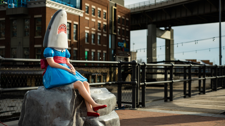 The statue of Shark Girl by artist Casey Riordan sits on a rock at Canalside