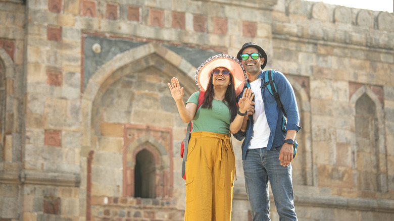 A happy smiling couple against a tourist site in India