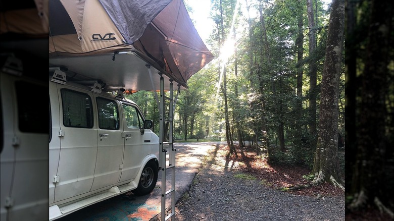 Van carrying tent in woods