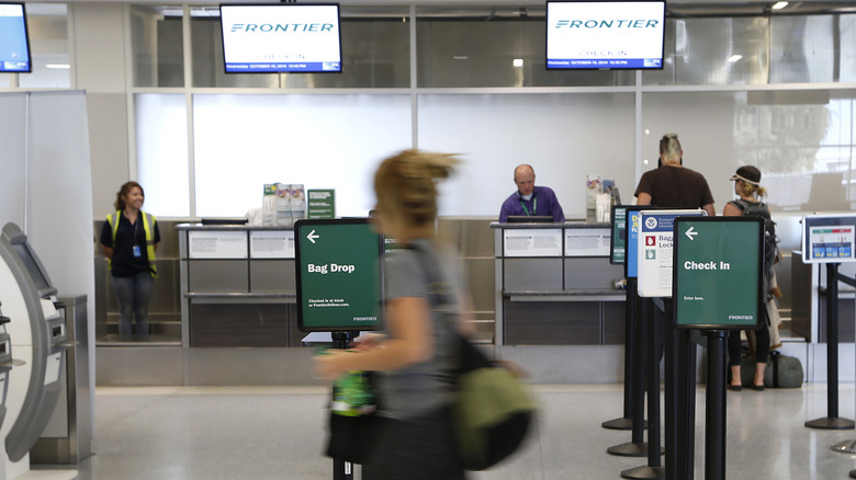 Frontier ticket counters at the airport with a passenger whizzing by
