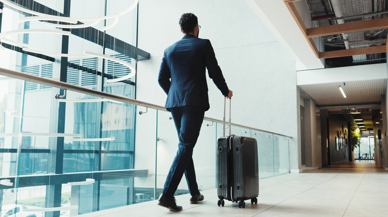 Person walking through the airport with their suitcase