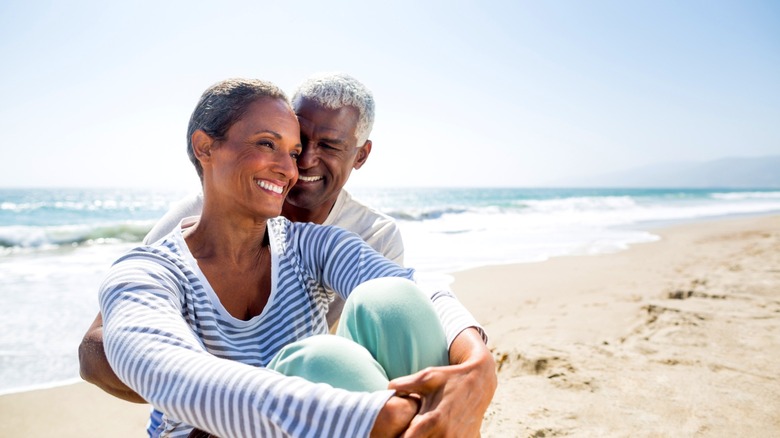 A retired senior couple sitting on the beach in California