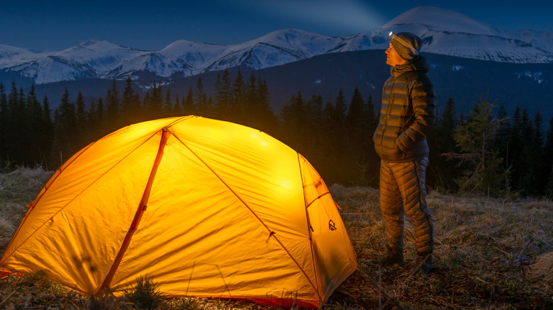 A camper in the wilderness with a headlamp